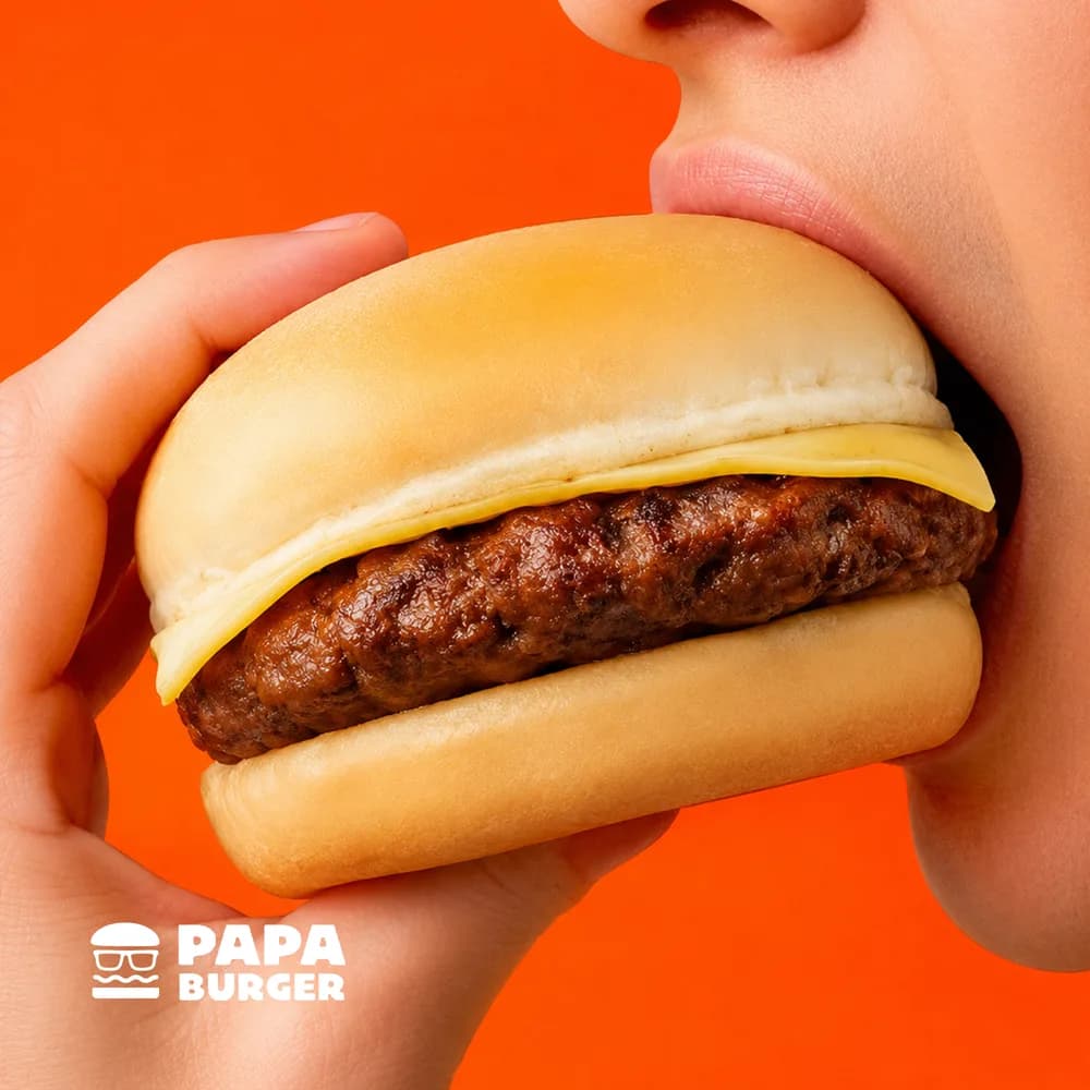 Someone raising a Papa Cheesy Burger to take a bite.