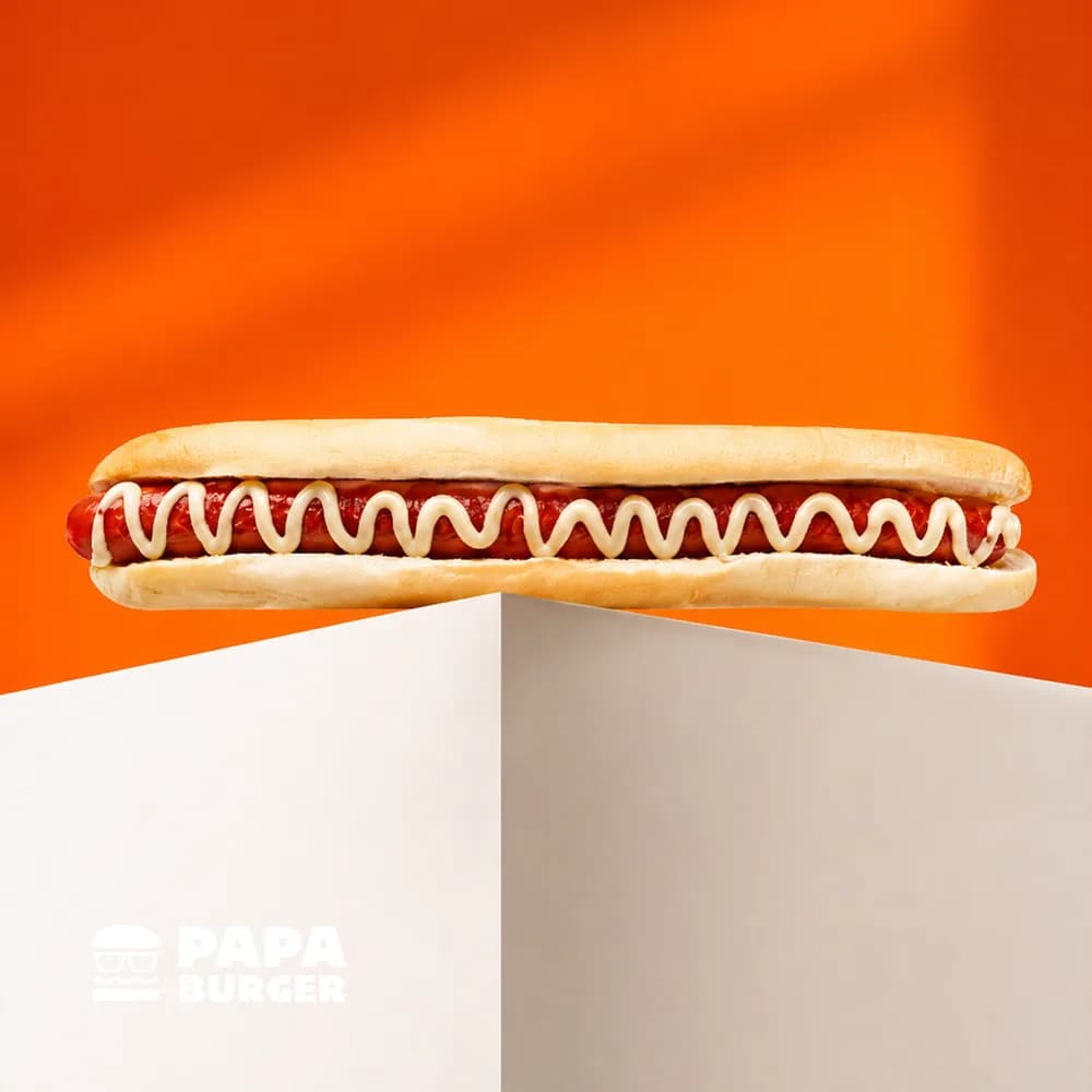 A Papa Cheesy Footlong balanced on a white plinth.