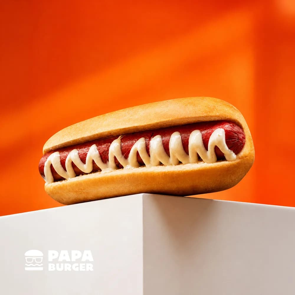 A Papa Cheesy Hotdog resting on a white plinth.
